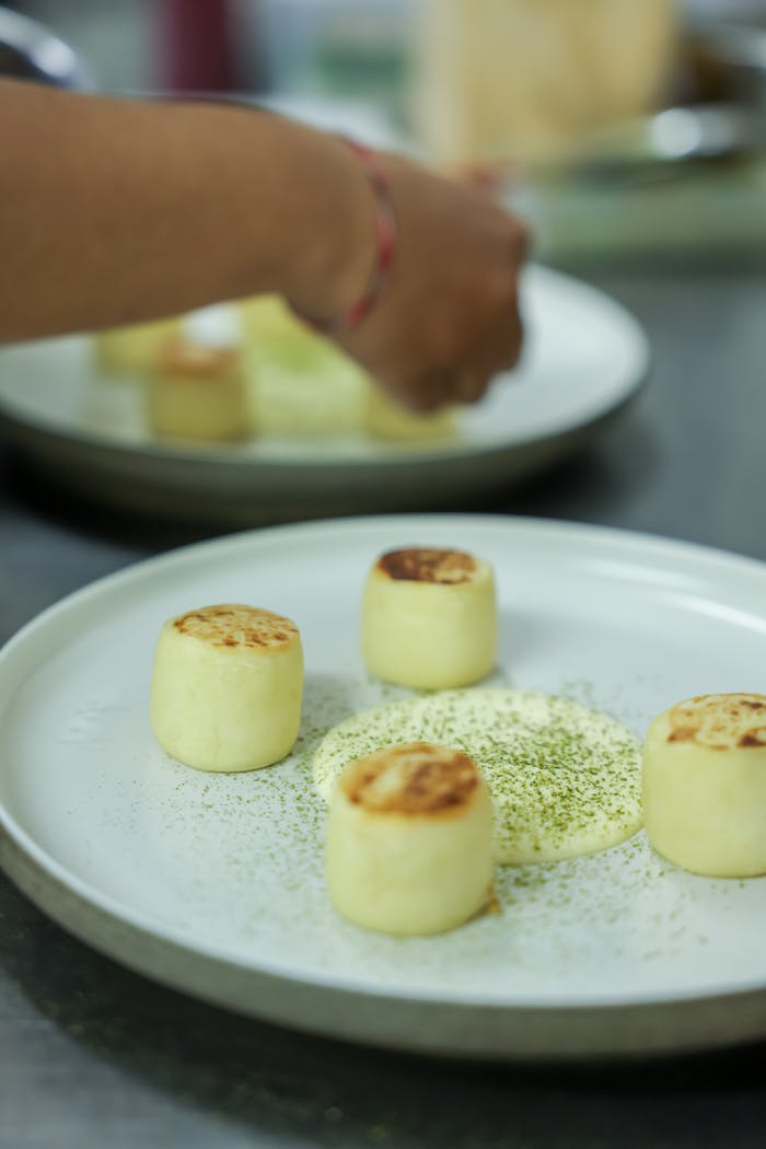 Gourmet plated desserts garnished with fine spices by a chef.