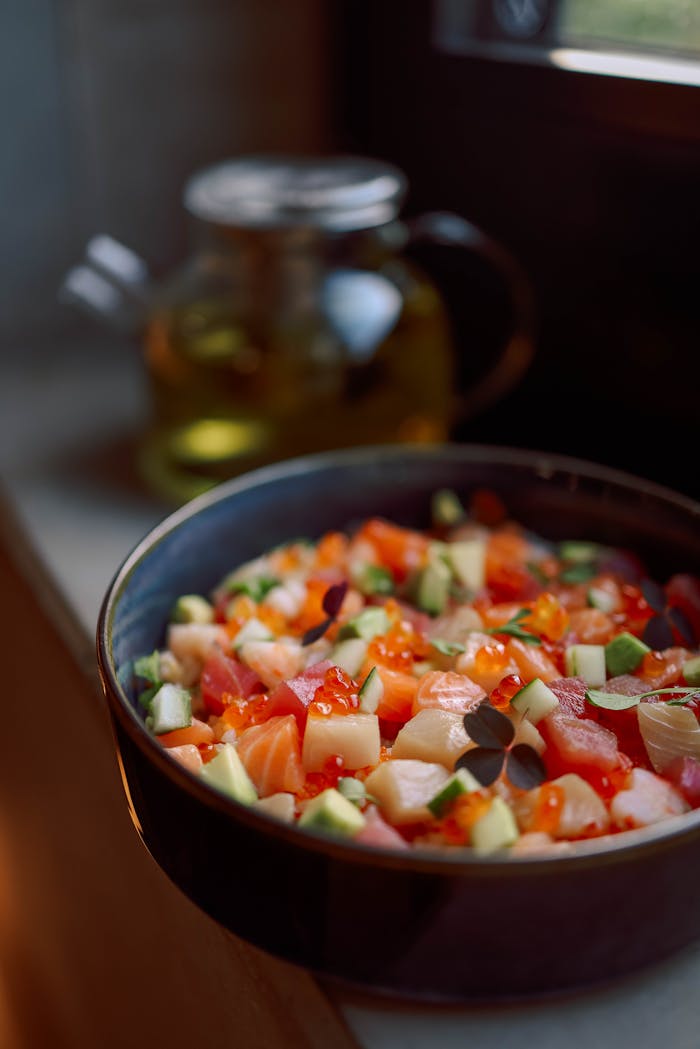 Delicious and vibrant salmon poke bowl with fresh ingredients by the window.