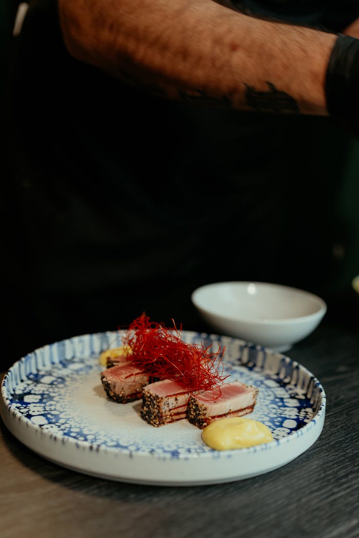 Elegant sesame crusted tuna served on a designer plate in an upscale setting.
